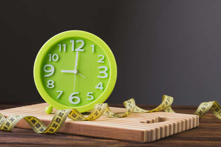 close up of green clock, diet concept background, measuring tapeの写真素材