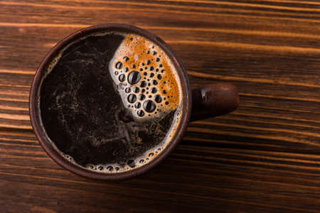 double americano in black coffee cup stands on wood tableの写真素材