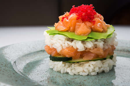 Japanese traditional dish sushi with rice and salmon, avocado at the plateの写真素材