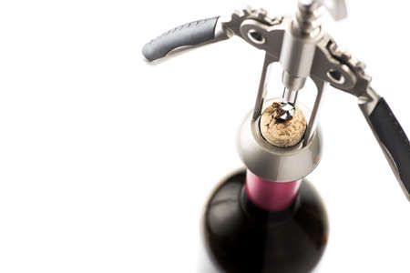 Red wine bottle opened by a corkscrew isolated on a white backgroundの写真素材