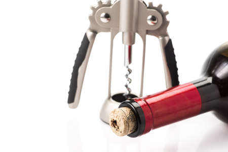 red wine bottle and corkscrew on white backgroundの写真素材