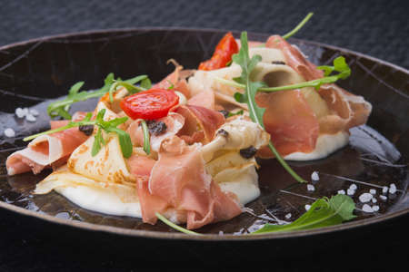 Delicious breakfast of pancakes and prosciutto meat in a frying panの写真素材