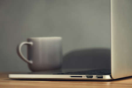coffee cup and laptop in office table. modern workplace studioの写真素材