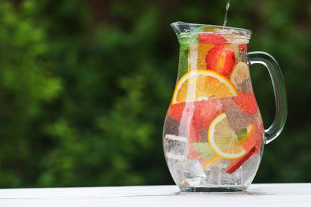 Carafe with mix refreshment cocktail on green backgroundの写真素材