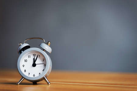 metal old alarm clock on wood table. Break in the office.の写真素材