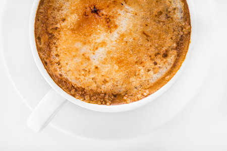 white coffee cup with foam on white backgroundの写真素材