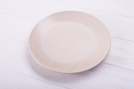 Empty ceramic plate on wood background. top viewの写真素材