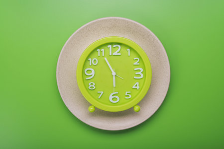 clock with measuring tape. diet concept. top view green backgroundの写真素材