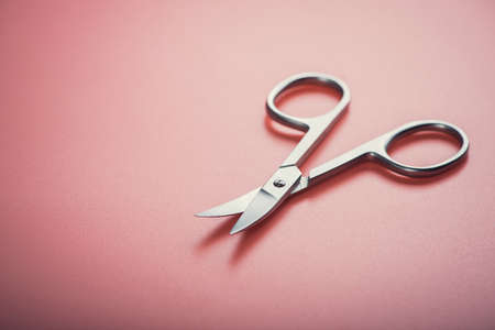 Cosmetic scissors on pink background. manicure tool equipmentの写真素材