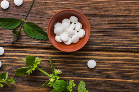Natural organic pills with herbal plant on wood table. ethnoscience concept.の写真素材