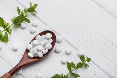 Natural organic pills with herbal plant on white wood table. ethnoscience concept