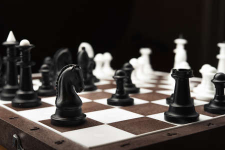 White and black chess pieces on a blackboardの写真素材