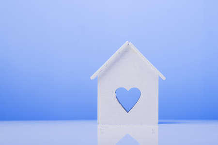 white house model icon with heart symbol on blue background. buying a house conceptの写真素材