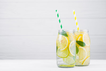 tasty lemonade drink with lemon, lime and mint on wood white tableの写真素材