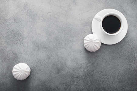 white ceramic cup with black coffee and marshmallow dessert on stone table. top viewの写真素材