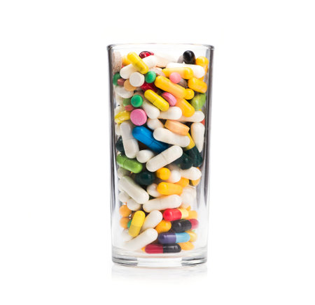 concept of glass and medical pills isolated on white background