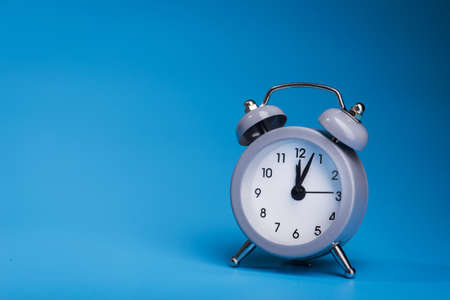 Metal alarm clock on a blue backgroundの写真素材