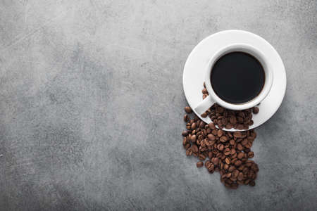 white coffee cup with roasted beans on stone table backgroundの写真素材