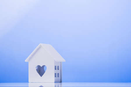 white house model icon with heart symbol on blue background. buying a house conceptの写真素材