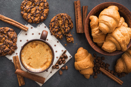 tasty coffee cup with sweet cookies and croissant on stone dark background. top view with copyspaceの写真素材