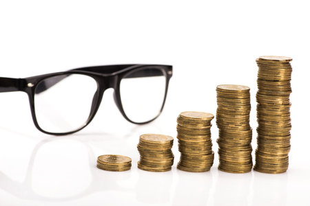 gold coins stack and black glasses isolated on white background, finance concept of a breakの写真素材
