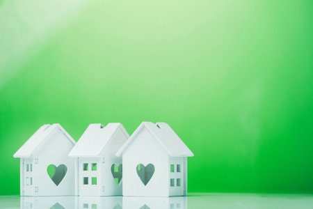 white house model icon with heart symbol on green background. ecological concept at homeの写真素材