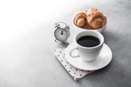 hot coffee cup with tasty croissant on stone table, fast businessman's lunch conceptの写真素材
