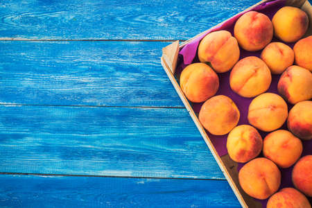 Fresh and ripe peaches in a wooden boxの写真素材
