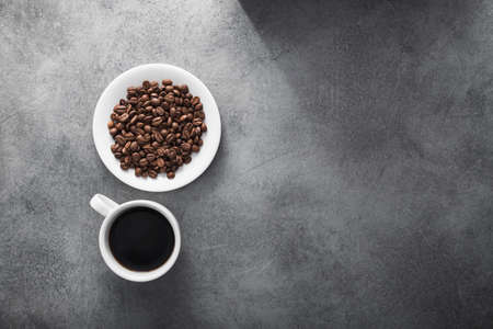 white coffee cup with roasted beans on stone table backgroundの写真素材