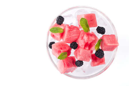 Cut into slice red watermelon with mint and ice on dish isolated on white background. top viewの写真素材