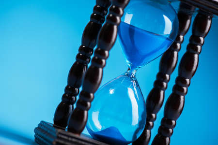 close up of hourglass on a blue backgroundの写真素材