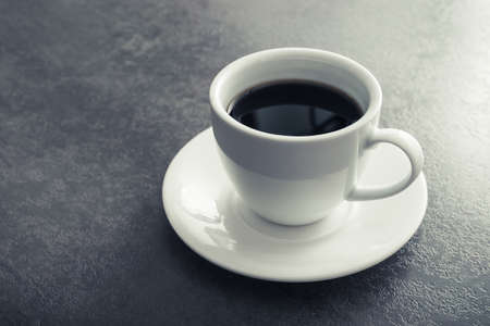 white ceramic cup with black coffee on stone tableの写真素材