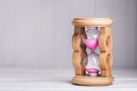 close up of hourglass on a white wood tableの写真素材