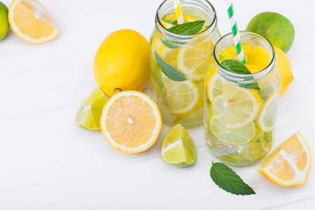 tasty lemonade drink with lemon, lime and mint on wood white tableの写真素材