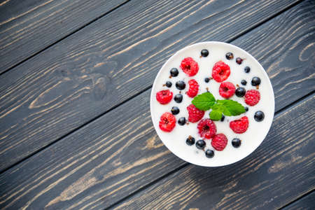 fresh yogurt with raspberry and green mint on wooden table. sweet dessert foodの写真素材