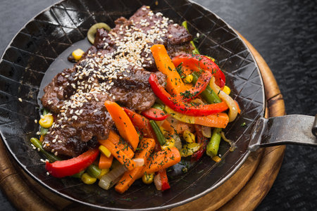 Grilled meat with sesame and grilled vegetables in a frying pan. restaurant serving mealsの写真素材
