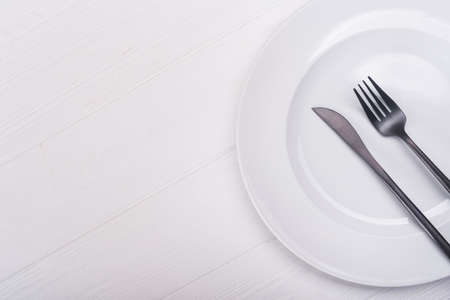 Empty white plate with knife and fork. view from topの写真素材