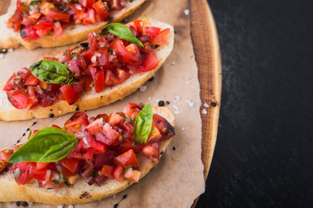 italian food appetizer, bruschetta with tomatoes and basil on wood boardの写真素材