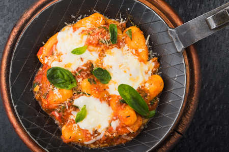 Omelette with mozzarella and basil in a frying pan. hot Italian dish at the restaurantの写真素材