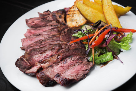 grilled beef steak with red pepper on black slate board. serving of meat in restaurantの写真素材