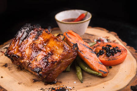 grilled meat ribs with vegetables on wooden cutting boardの写真素材