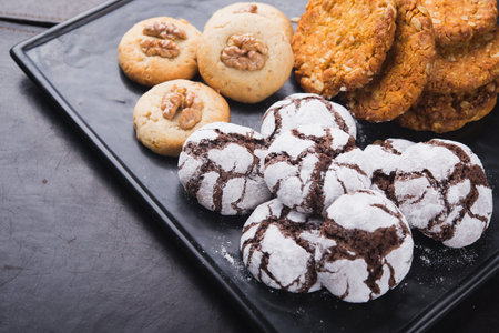 sweet cookies with chocolate and nuts on black board