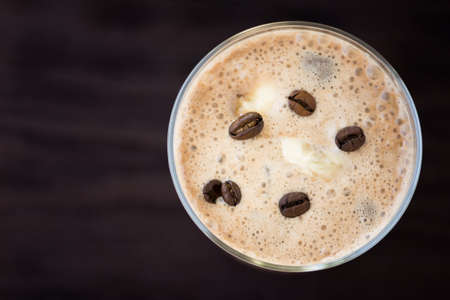 Coffee smoothies with roasted beans on black tableの写真素材