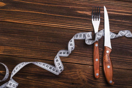 fork and knife with white measuring tape. diet food backgroundの写真素材