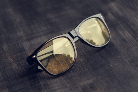 black glasses with reflection on the wooden table