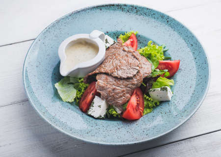 Salad with veal, tomato and feta on plateの写真素材