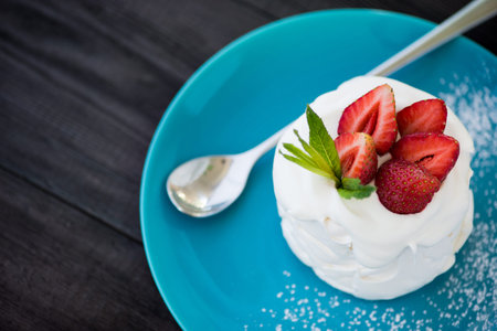 dessert pavlova with strawberry fruit on blue dishの写真素材