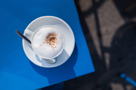 coffee cup with foam on the blue restaurant table, top viewの写真素材