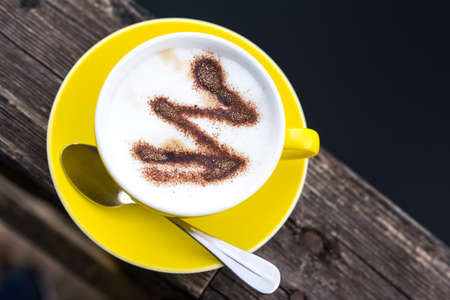 Yellow coffee cup on a wooden board, restaurant on the pierの写真素材