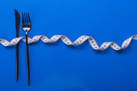 fork and knife with white measuring tape. diet food backgroundの写真素材